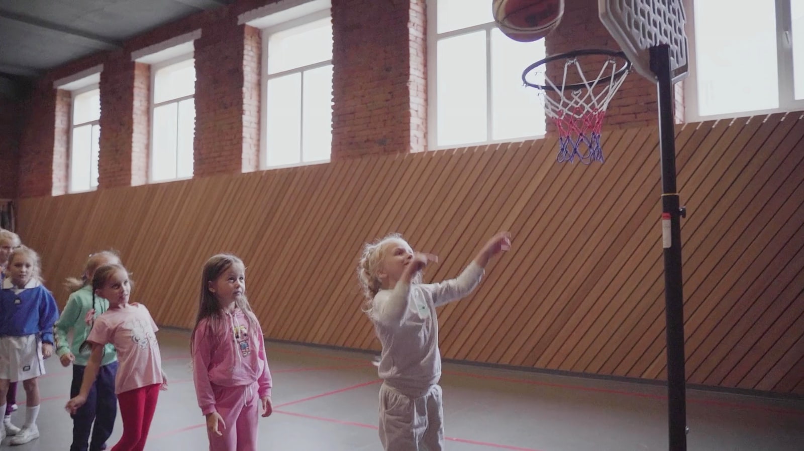 Kids practicing basketball shooting drills in a gym
